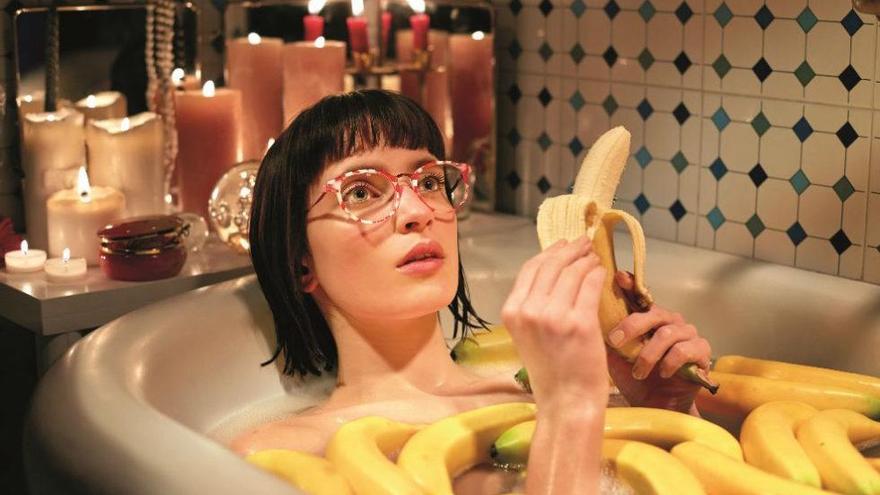 Chica con gafas de Etnia Barcelona en una bañera llena de plátanos
