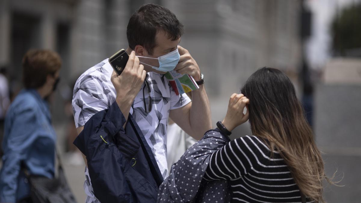 Un hombre se quita la mascarilla.