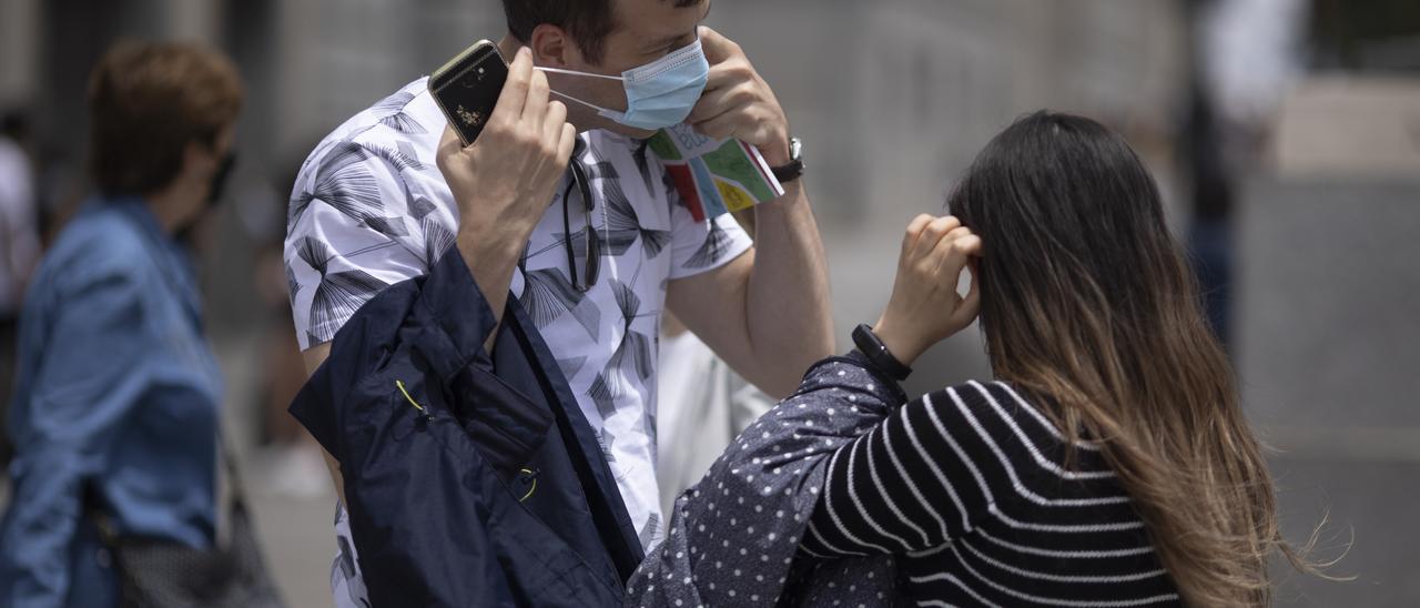 Un hombre se quita la mascarilla.