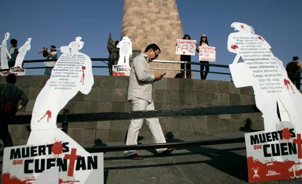 Un home camina entre manifestants i unes figures humanes de cartró on es pot llegir Morts que compten. És durant una protesta a Guadalajara (Mèxic), impulsada pel poeta Javier Sicilia. El seu fill va ser trobat mort amb sis persones més en un cotxe la setmana passada.