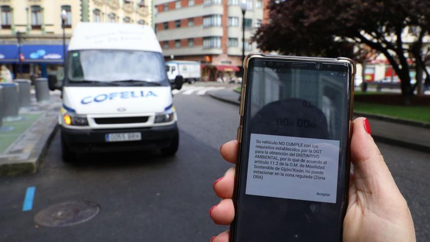 Una conductora muestra un mensaje en su móvil que le prohíbe estacionar en la zona ORA, en la plazuela de San Miguel. | Juan Plaza