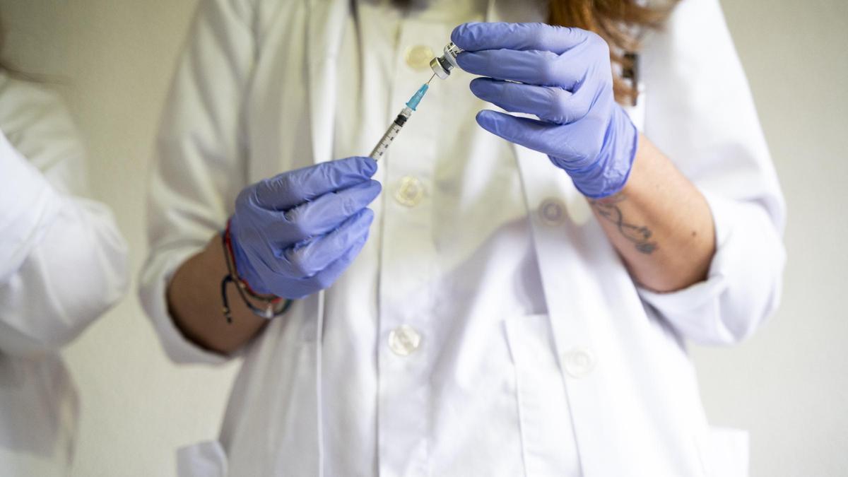 Una enfermera prepara una dosis de una vacuna.