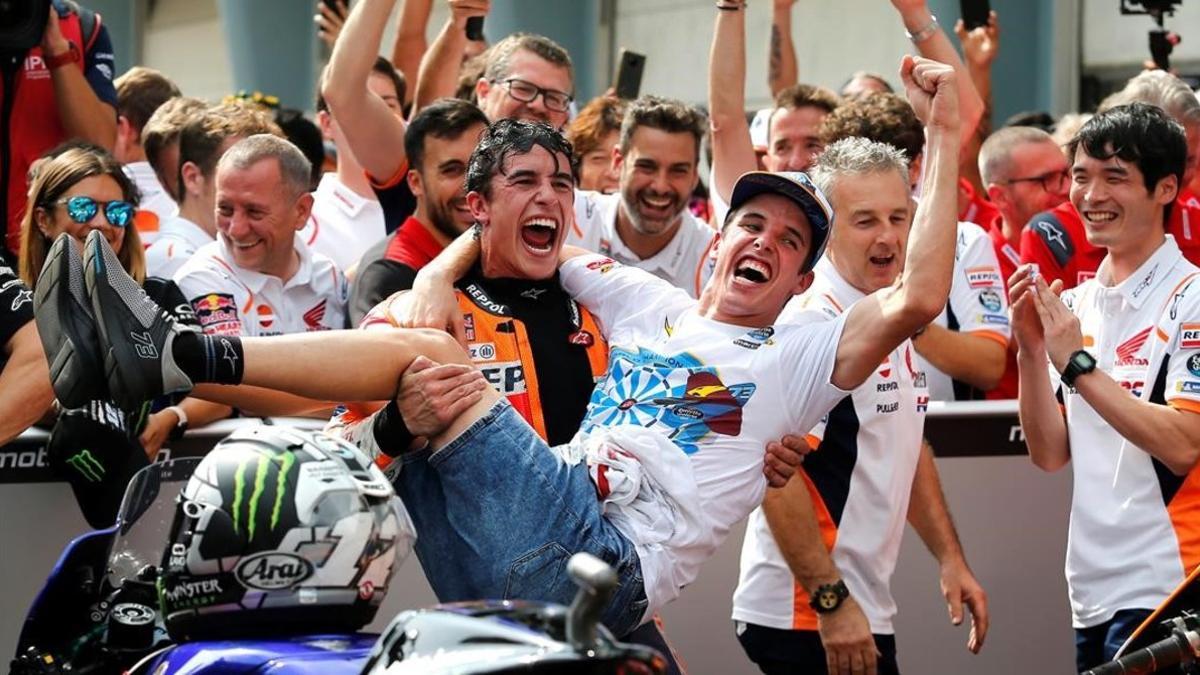 Marc Márquez levanta a su hermano Àlex, tras el segundo puesto conseguido por el mayor en MotoGP.