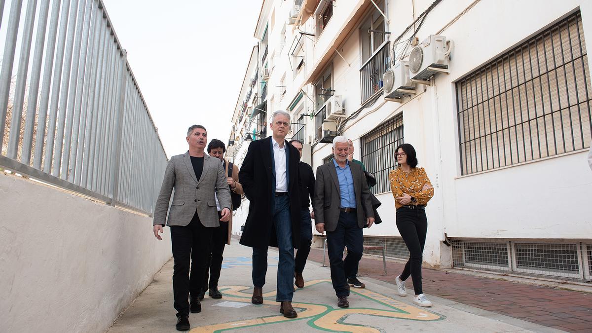 El conseller Hector Illueca pasa, acompañado por el alcalde y concejales de Altea, junto a uno de los edificios a rehabilitar en la calle Zubeldia