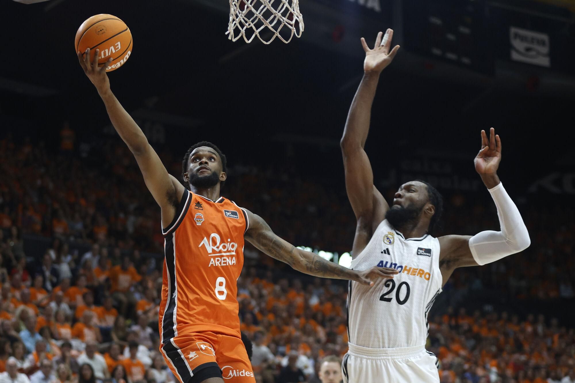 VALENCIA, 25/06/2025. El escolta del Valencia Jean Montero (i) entra a canasta ante Bruno Fernando, del Real Madrid, durante el tercer partido de la final de la Liga Endesa que Valencia Basket y Real Madrid disputan hoy miércoles en el pabellón de la Fuente San Luis. EFE/Miguel Ángel Polo