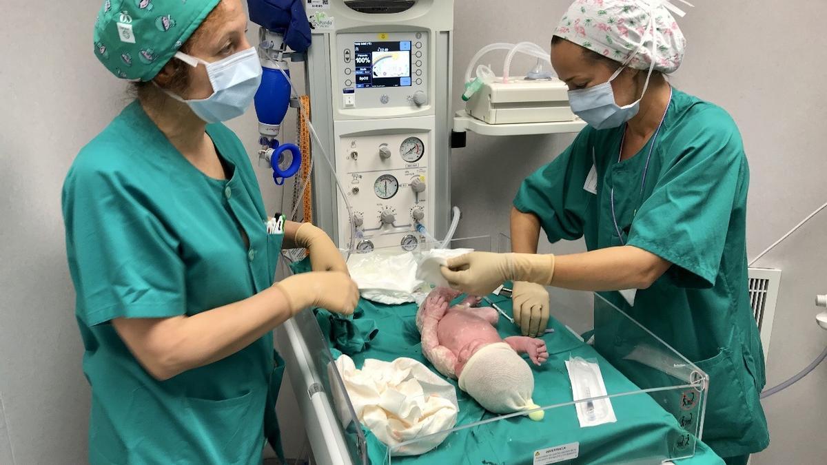 Archivo - Dos sanitarias atienden a un bebé recién nacido en Almería
