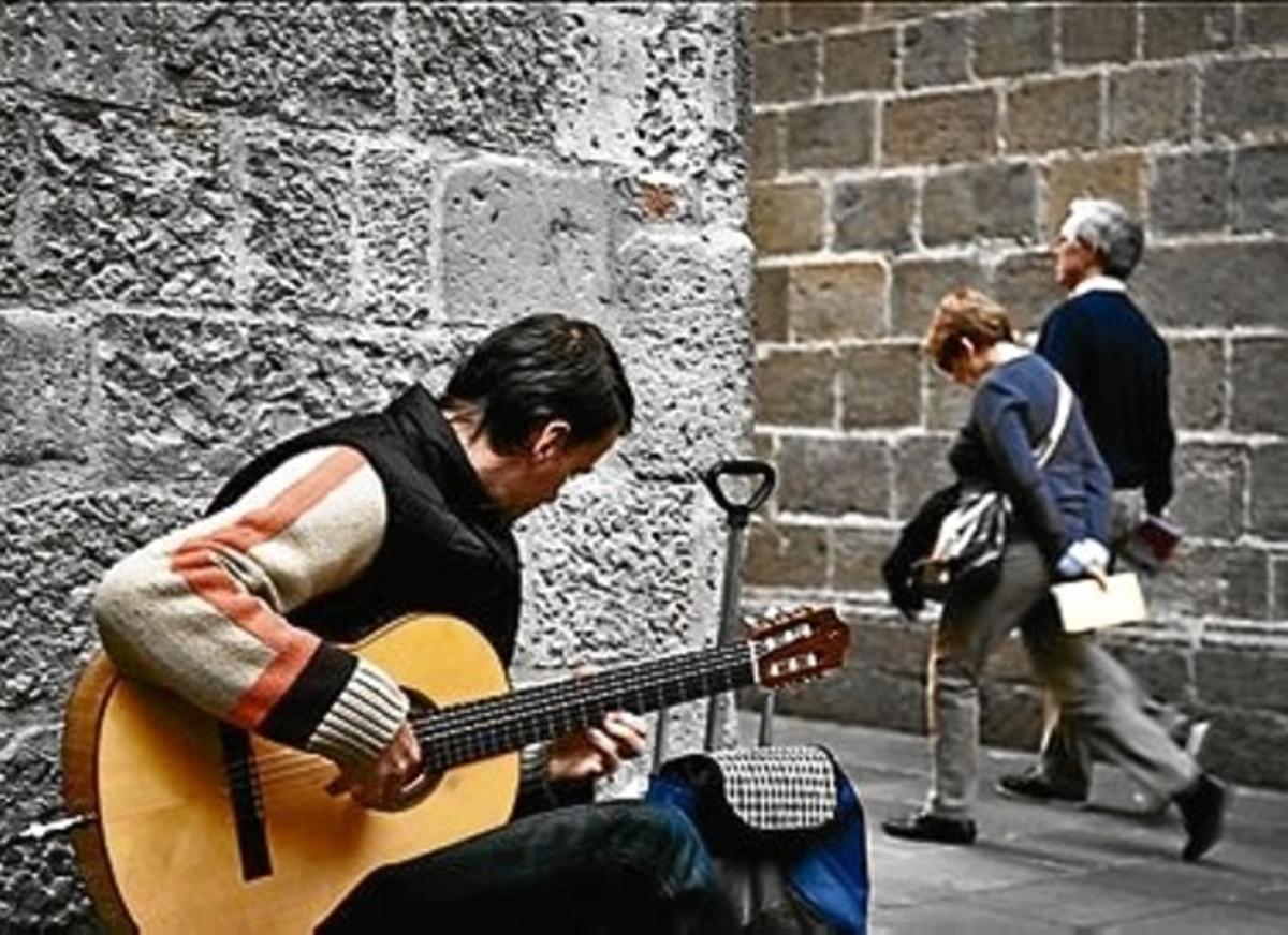 Un músico callejero en el Barri Gòtic, el pasado lunes.