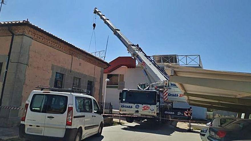 Una grúa en las afueras del centro de salud de Bermillo traslada material para montar la estructura.