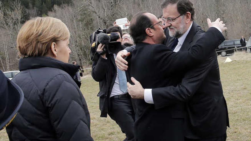 El presidente Hollande se abraza a Mariano Rajoy, en presencia de Angela Merkel.