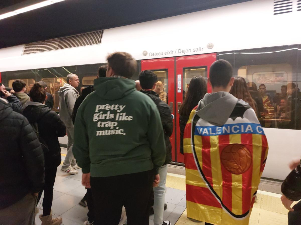 Aficionados del Valencia esperando el metro tras un partido.