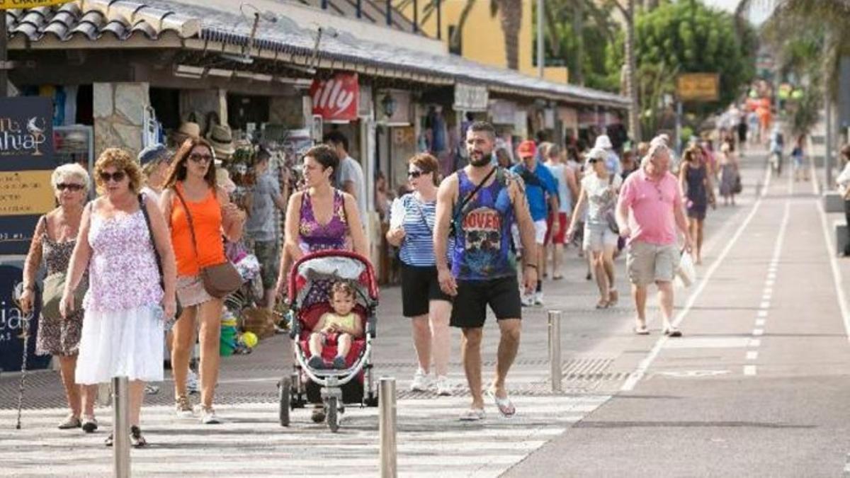 Un numeroso grupo de personas transitan por una de las calles de Corralejo.