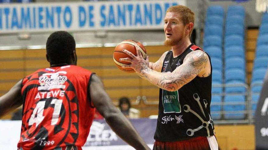 Robert Swift busca a un compañero para pasarle el balón ante la presencia del local Atewe.