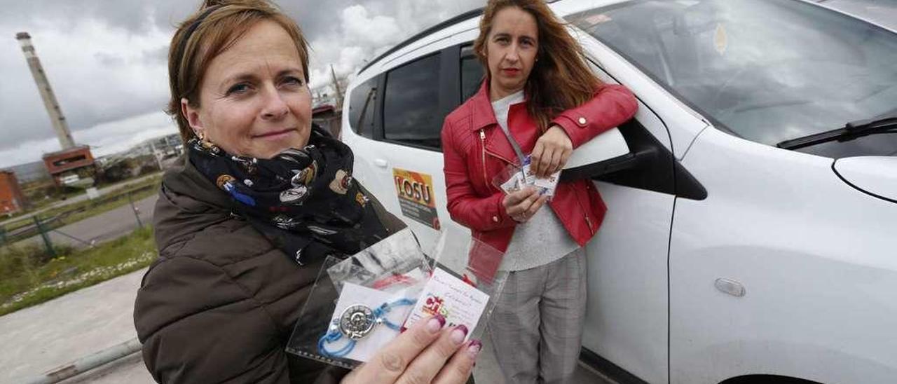 Rebeca Fernández y Tere García sostienen las pulseras, colgantes y llaveros que venden para recaudar fondos para la Fundación Cris.