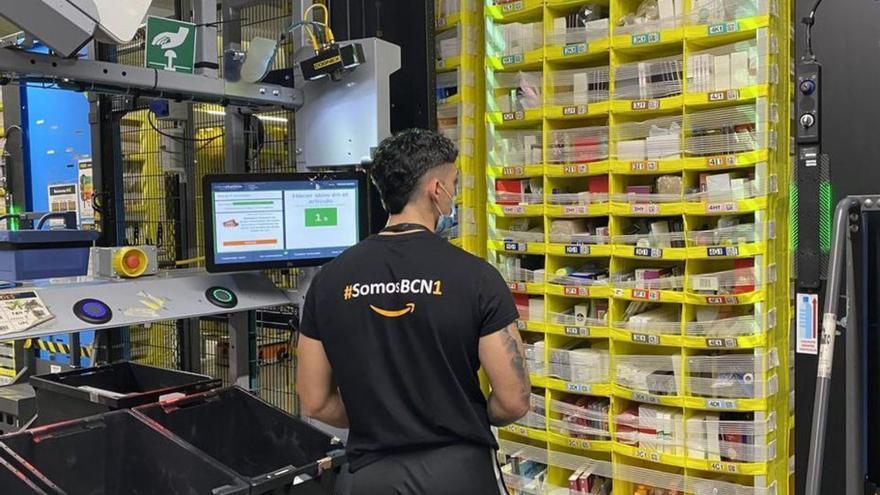Un empleado de la empresa de logística Amazon incorpora productos al almacén de Amazon en El Prat.  | L.O.