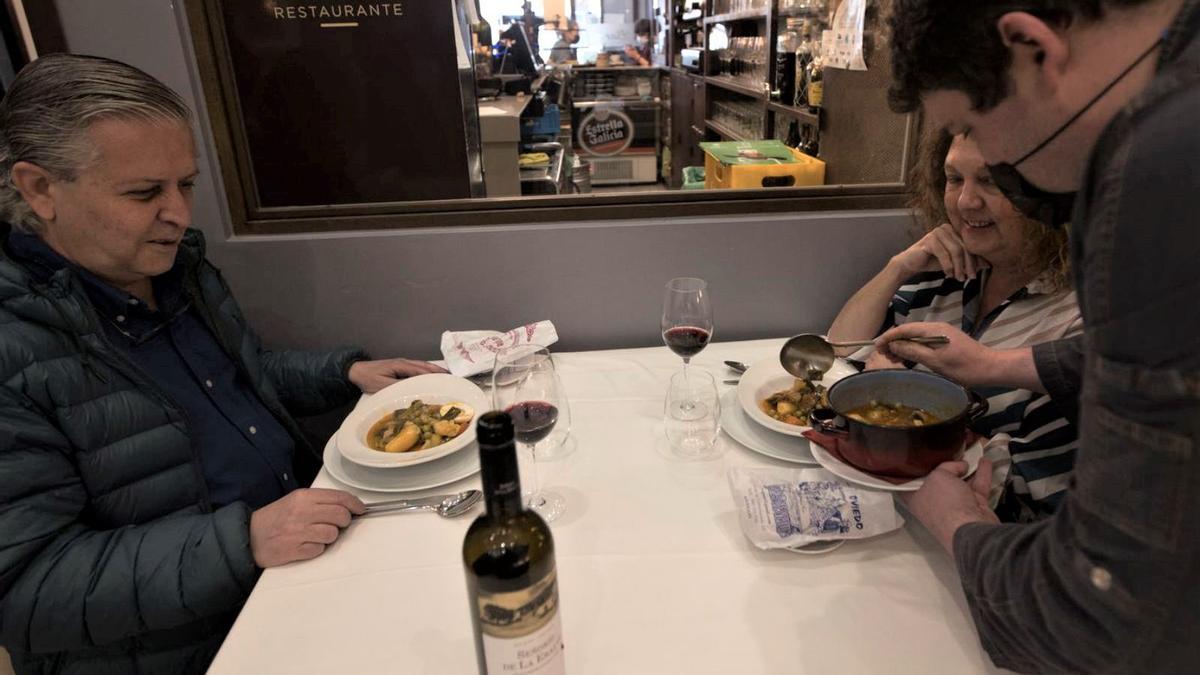 un cocinero sirviendo uno de los platos del menú durante en 2021