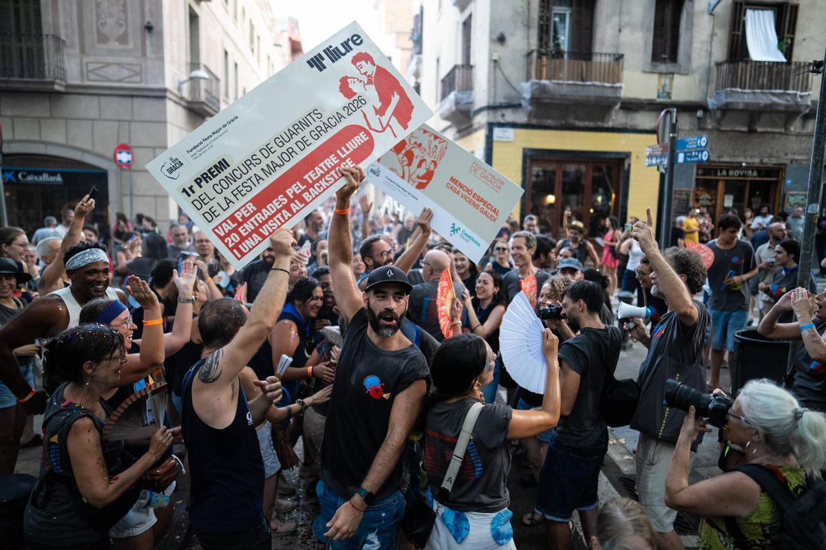 Vecinos y participantes celebran en la plaza Rovira el premio obtenido por su decoración durante la Festa Major de Gràcia