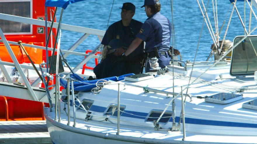 Dos policías escoltan un yate en el que se intervino droga.