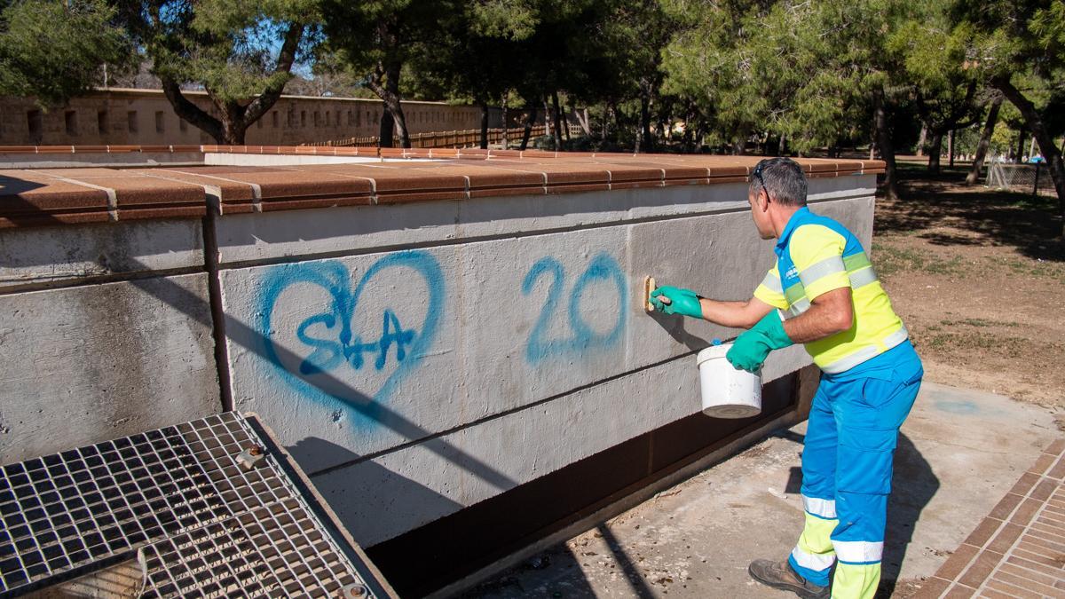 Un operario de Emaya elimina una pintada de la pared de un parque.