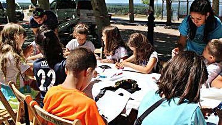 Niños y monitores trabajando en el taller de imanes del &quot;Muévete&quot;.