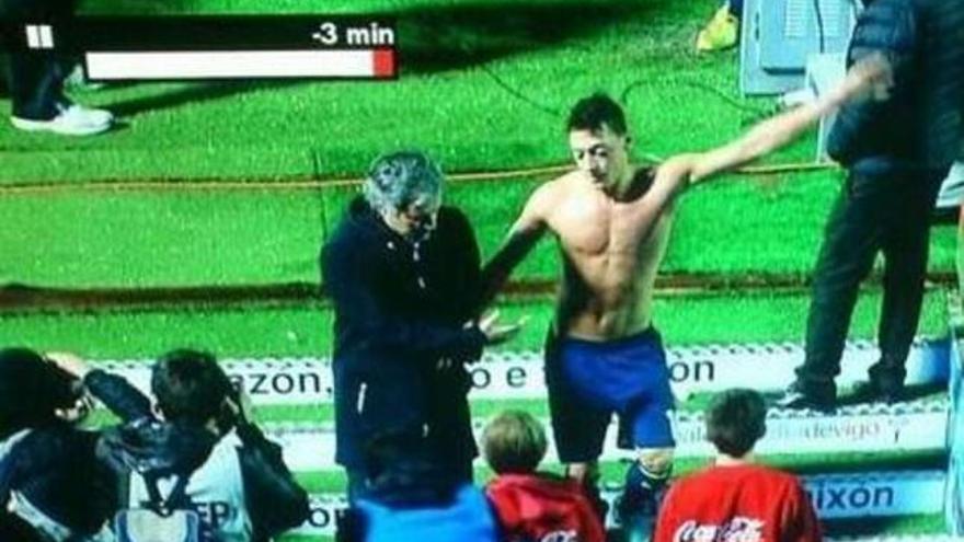 Imagen de Özil con Mourinho, en el momento de lanzar la camiseta hacia un recogepelotas. // Canal Plus