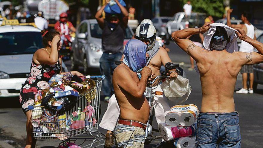 Saqueadores de un supermercado de Managua durante las protestas, que continuaron ayer. // AFP
