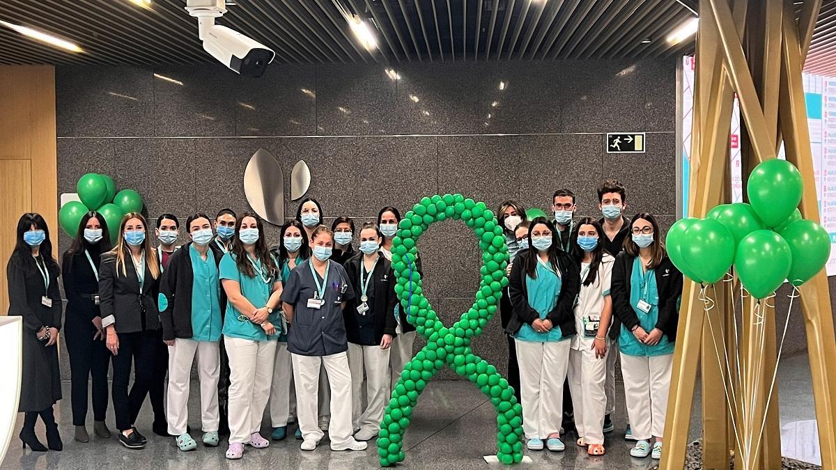Profesionales del Hospital Quirónsalud Córdoba junto a globos y lazo de color verde, que representa la lucha contra el cáncer.