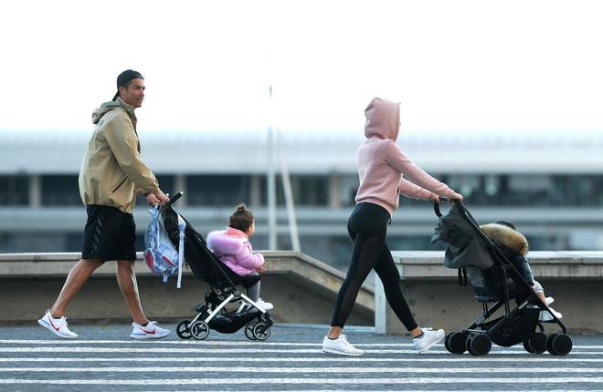 Cristiano Ronaldo (L) y su compañera Georgina Rodríguez empujan dos cochecitos mientras pasean con sus hijos en Funchal.