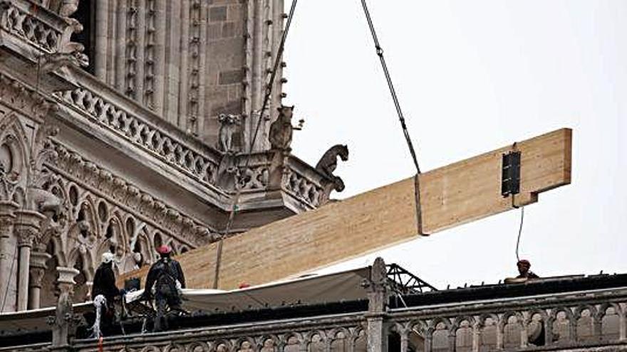 Uns obrers protegeixen de la pluja la catedral de Notre-Dame