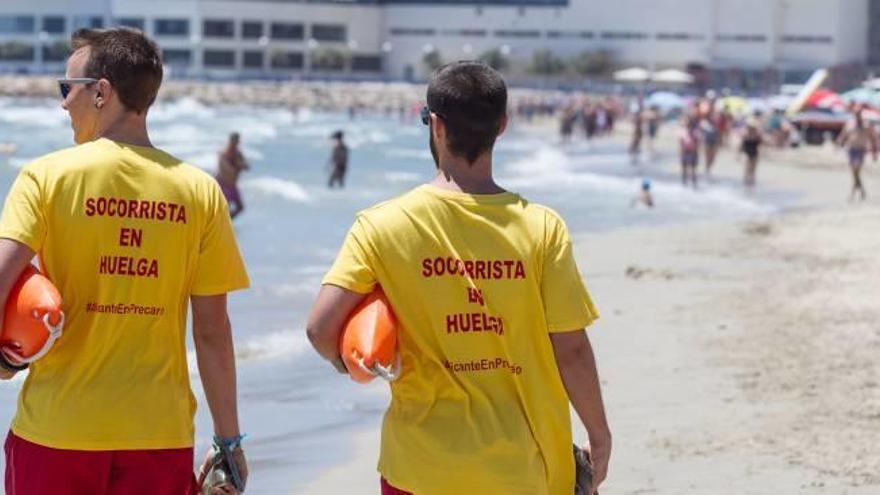 Dos socorristas pasean por la playa del Postiguet, durante la huelga del mes de junio.