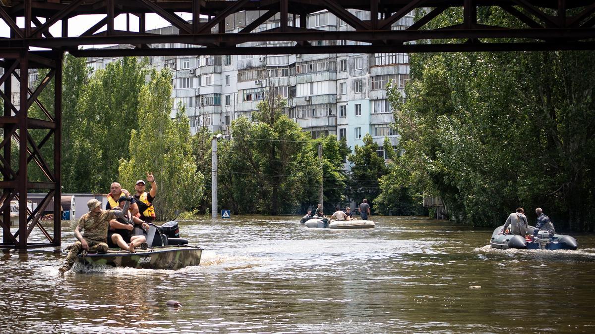 Los voluntarios entregan alimentos a los residentes locales en un área inundada, en medio del ataque de Rusia a Ucrania, en Kherson