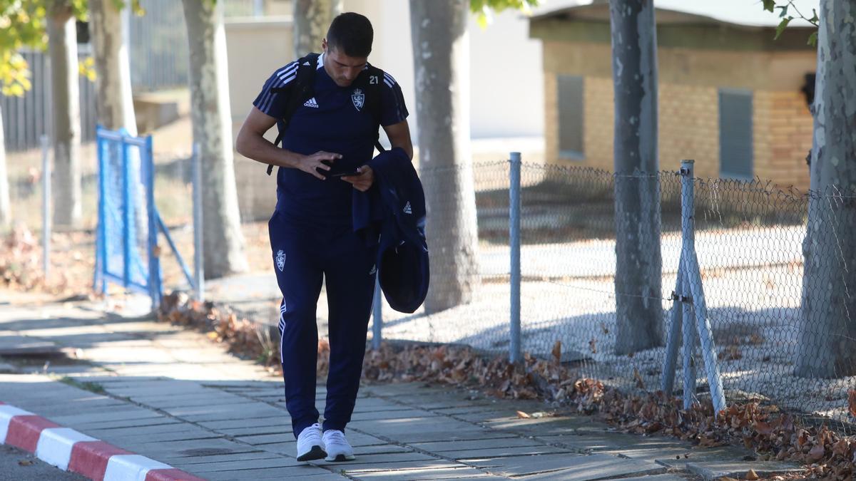 Alberto Zapater maneja su teléfono móvil mientras camina hacia el autocar que desplazó a la expedición, este viernes, desde la Ciudad Deportiva hasta la estación.