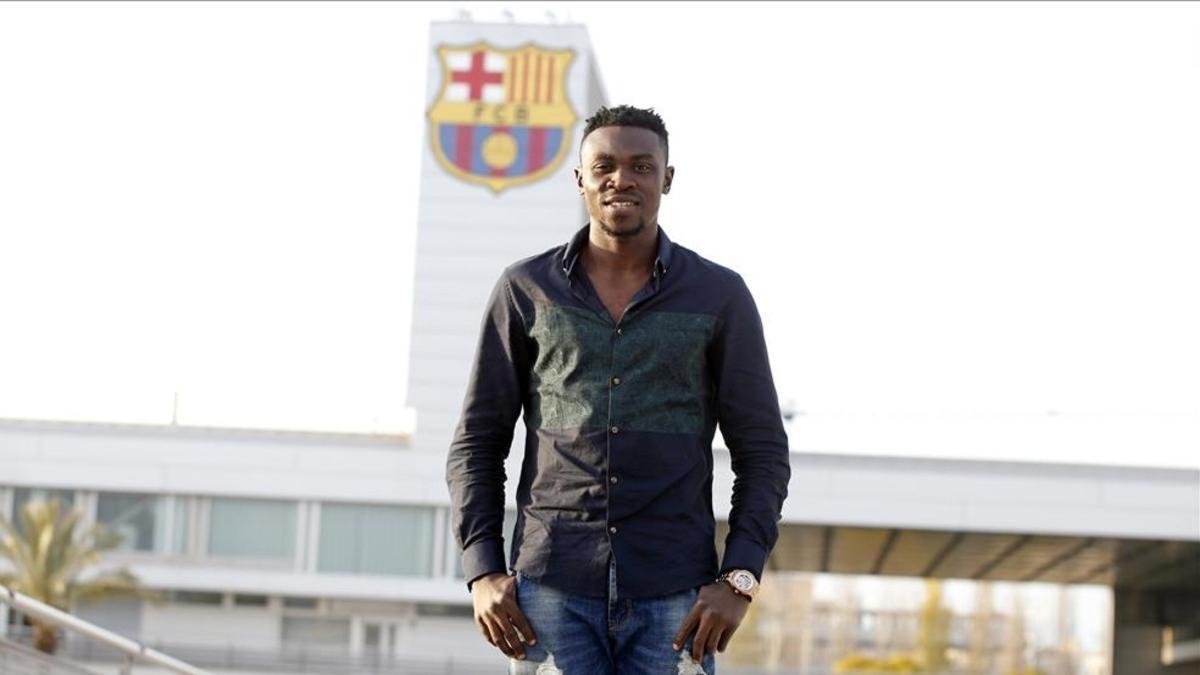 Ezekiel Bassey, posando junto al escudo del Barcelona