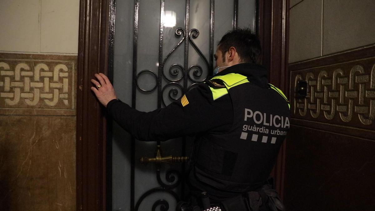 Un agente de la Guardia Urbana llama a un domicilio tras recibir el aviso de un vecino.