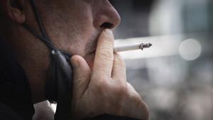 Un hombre fuma en una calle de Barcelona.