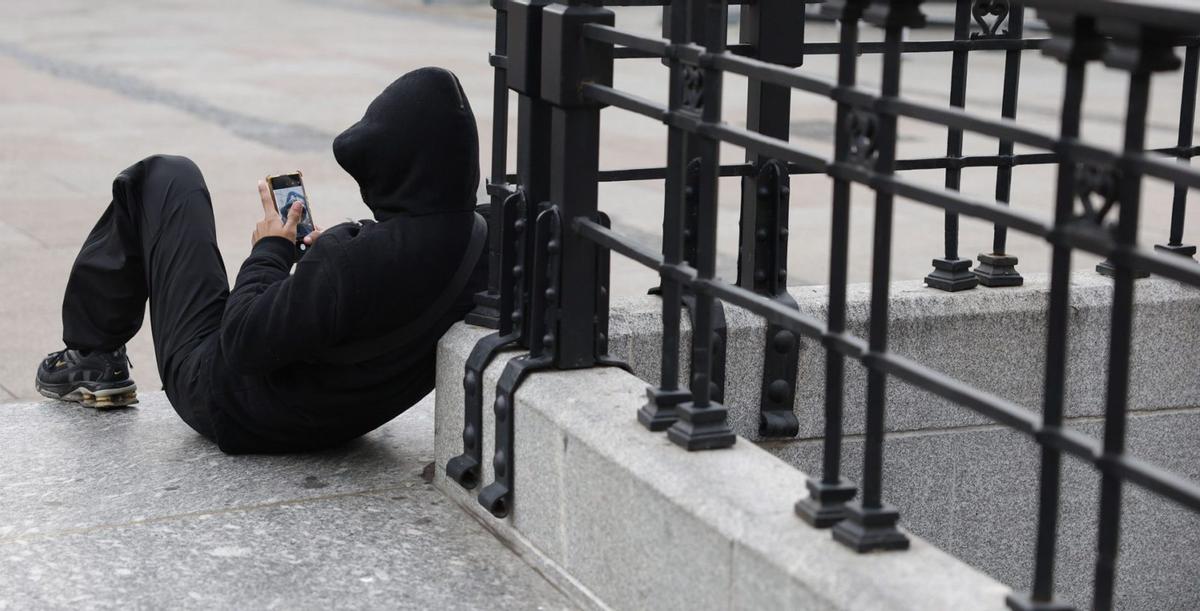 Un joven, en la calle con su teléfono móvil.  | EFE/MARISCAL