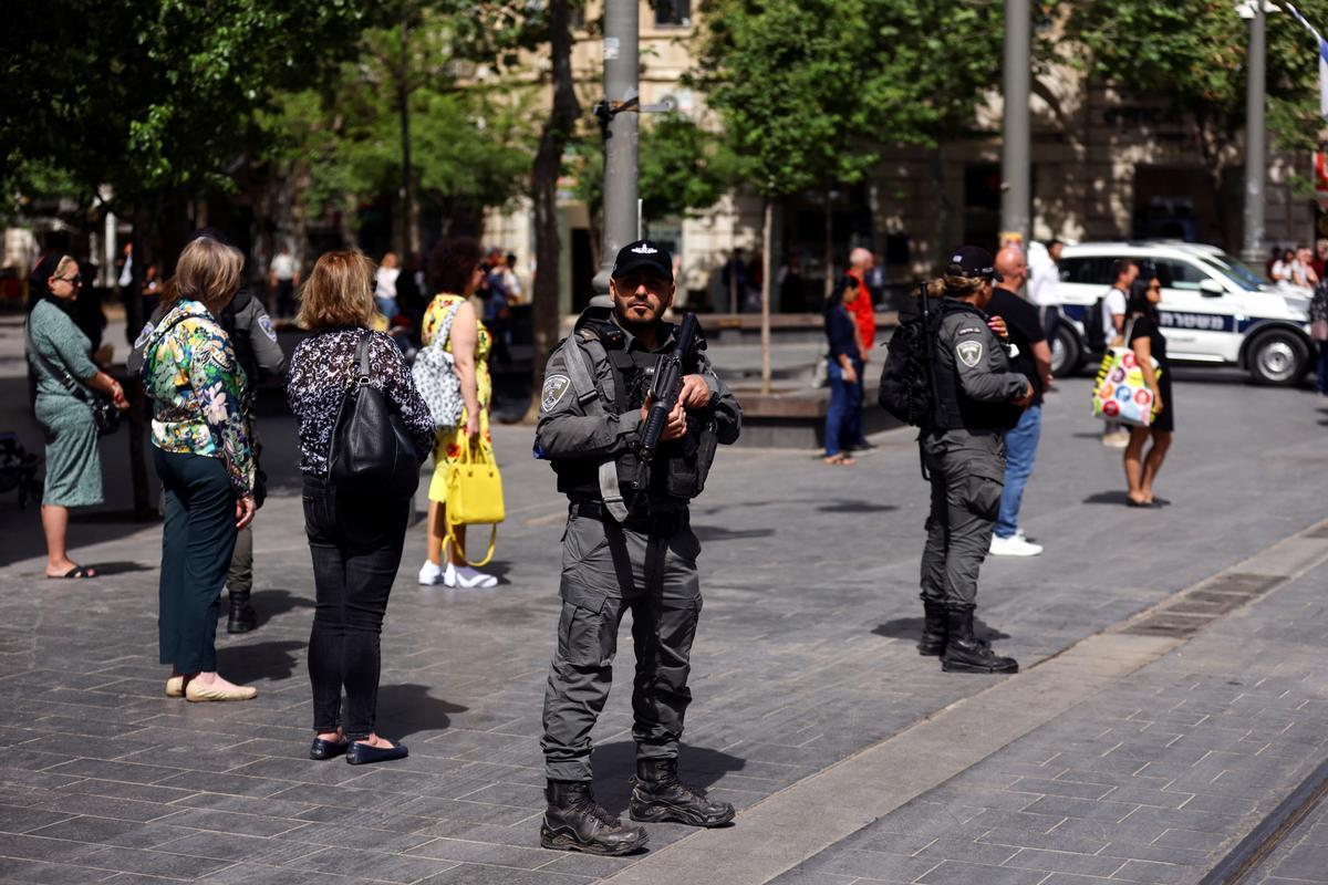 Miembros de las fuerzas de seguridad y ciudadanos, de pie y en silencio en una calle de Jerusalén, durante los dos minutos en los que han sonado las sirenas en conmemoración del Día de recuerdo del Holocausto.