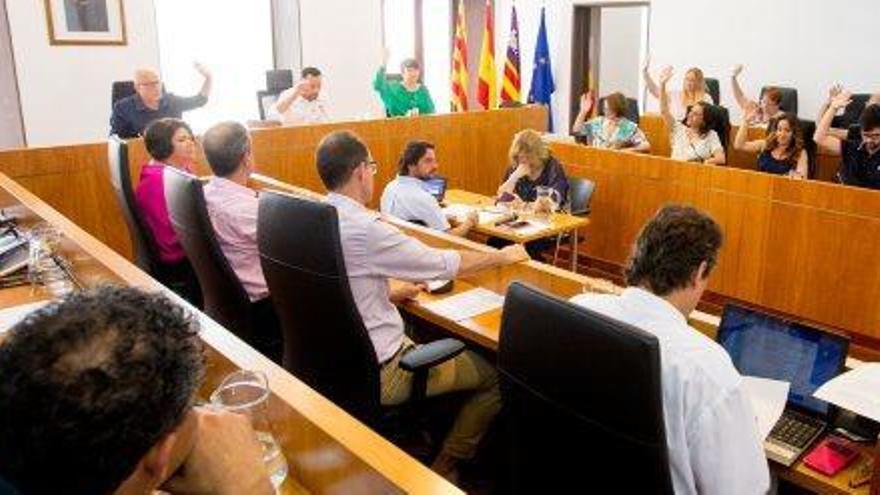 El equipo de gobierno alza el brazo durante una votación en el pleno.