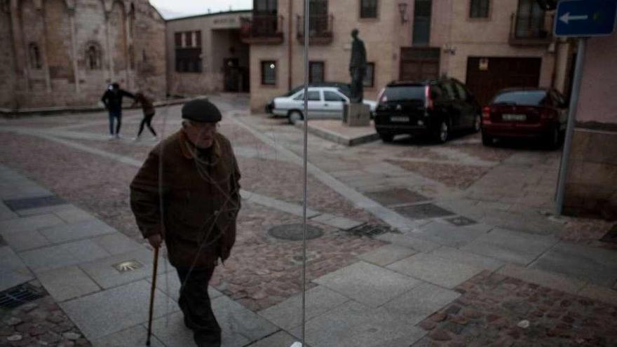 Un anciano pasea junto a la iglesia de S anta María la Nueva.