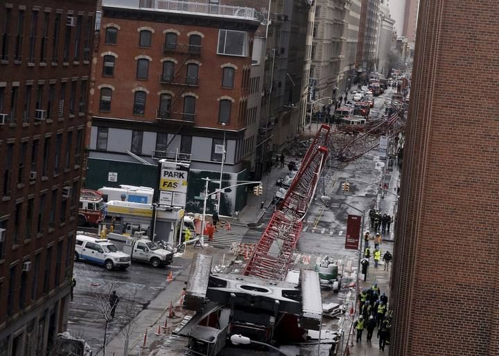 Emergency responders respond to the scene of a 565-foot-tall crane that toppled and flipped upside down, stretching along nearly two city blocks in downtown Manhattan in New York