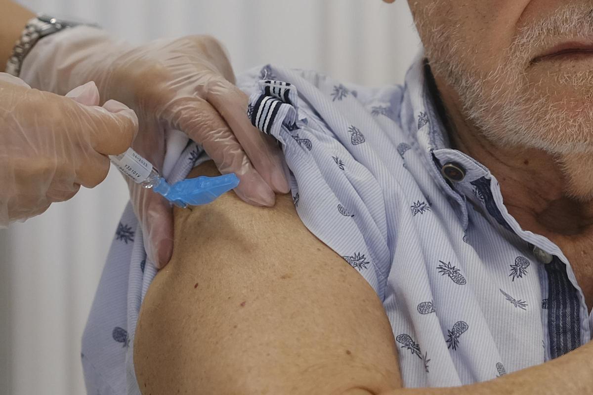 Un hombre recibe la vacuna contra la gripe.
