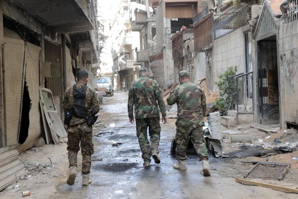 XYB01. Damascus (Syrian Arab Republic), 08/04/2018.- Syrian soldiers walk around at a street in Zamalka town, Eastern Ghouta, in the countryside of Damascus, Syria, 08 April 2018. The city was recently recaptured by the Syrian government during a military offensive that was launched more than a month ago against rebels. (Damasco, Siria) EFE/EPA/YOUSSEF BADAWI