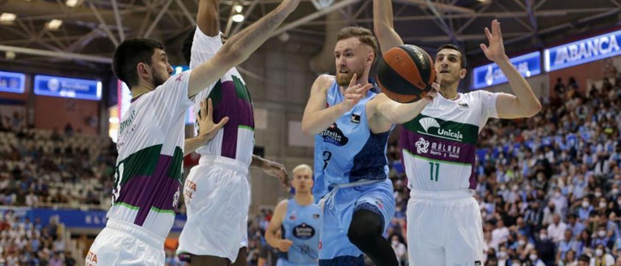 Dzanan Musa ante varios defensores del Unicaja.