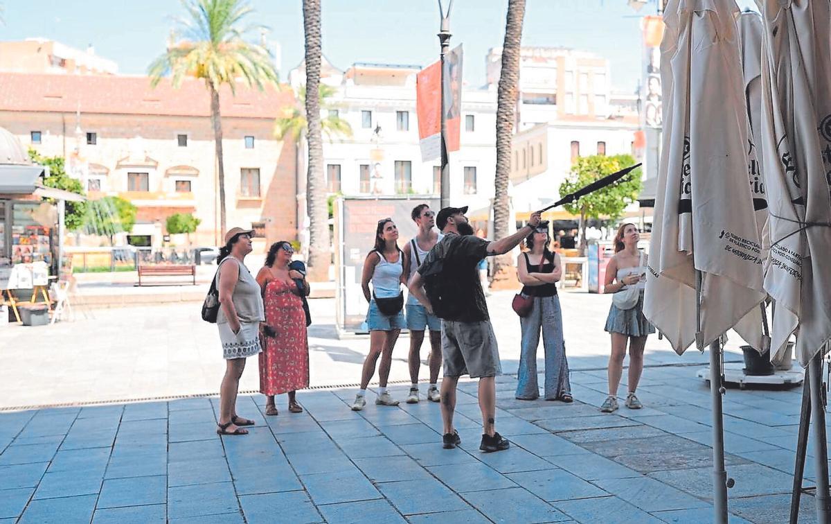 Visita turística en la plaza de España de Mérida, durante la ola de calor.