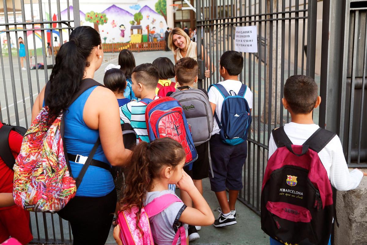 GRAF874. BARCELONA, 12/09/2018.- Niños a la puerta del colegio a la espera de la apertura de puertas en el primer día de curso. Más de 1.500.000 alumnos de infantil, primaria y secundaria catalanes inician hoy el curso escolar, en el que se aplicará la evaluación por competencias para la ESO y está previsto activar el pacto contra la segregación escolar. EFE/Alejandro García