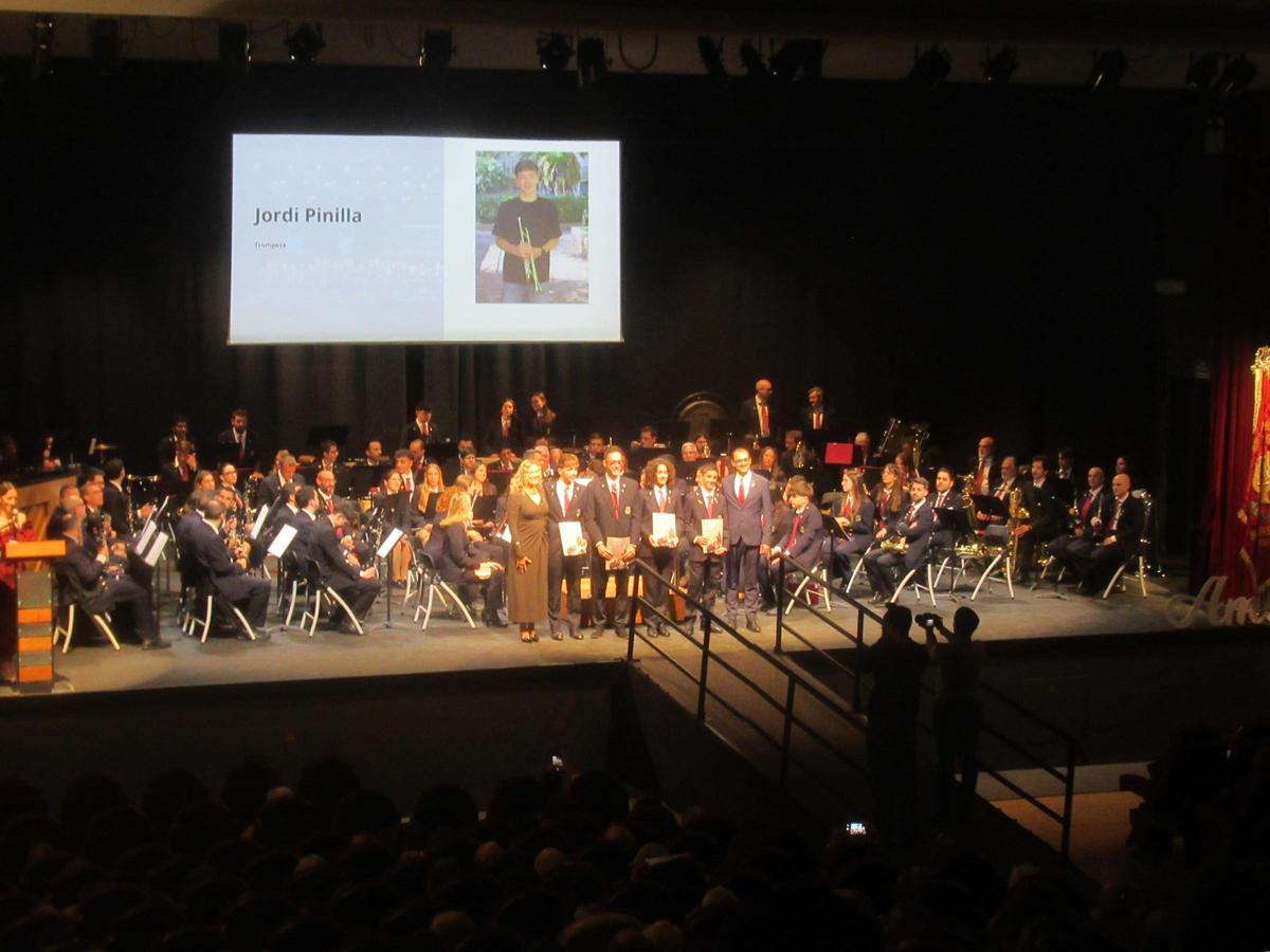 La Banda Sinfónica con los nuevos músicos, de pie, en el escenario.