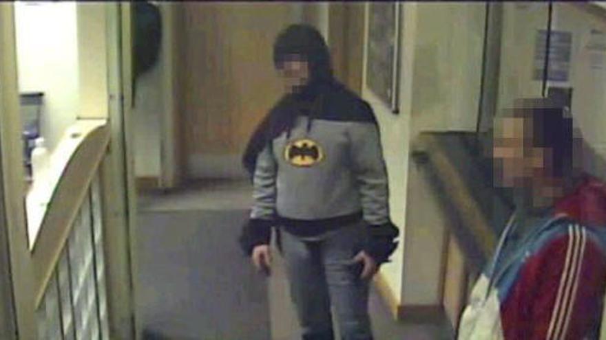 Un hombre vestido de Batman entrega a un criminal a la Policía