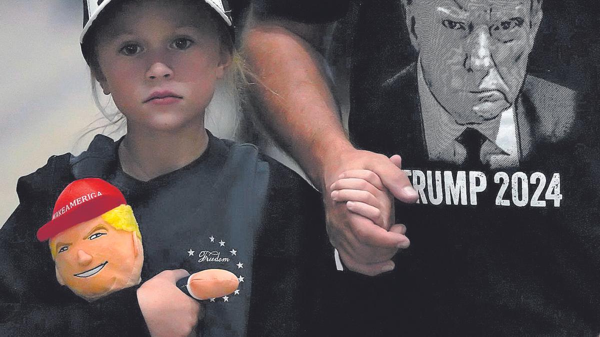 Una niña con un peluche de Trump, camino de un mitin en octubre de 2024 en Reno (EEUU).