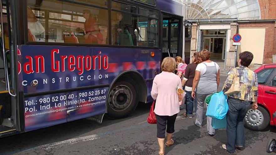 Varios usuarios suben al autobús de la línea 1 en la parada del Mercado de Abastos