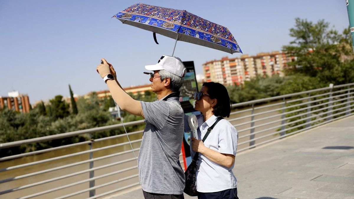 Una pareja se protege del sol en Zaragoza, en una imagen de archivo