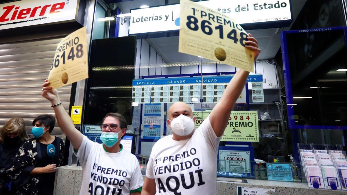 Els responsables de l’administració de loteria eufòrics després d’haver donat el primer premi amb el 86.148 venut a la popular i concurreguda estació de tren d’Atocha de Madrid. | EFE